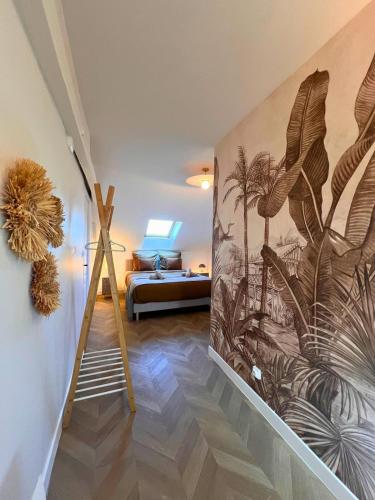 a bedroom with a mural of palm trees on the wall at Maisons Sauvage 3 3 Bis in Romorantin