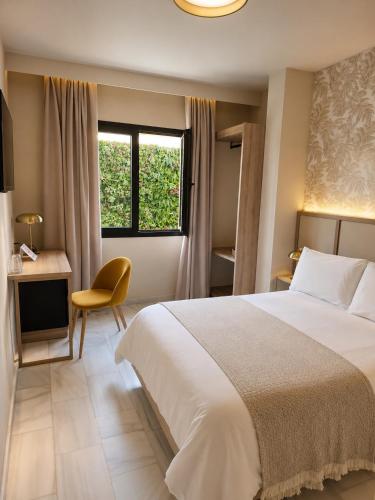 a bedroom with a bed and a desk and a window at Zarú Hotel Boutique in Mocejón