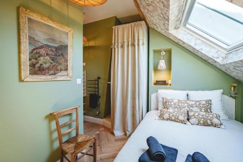 a bedroom with a bed with a window and a chair at La Maison dAmbre-Jacuzzi-Sauna-Clim-4chambres in Saumur