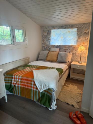 a bedroom with a bed and a table with a lamp at BAPA STAYs COZY CABIN A by the Ivö lake in Kristianstad