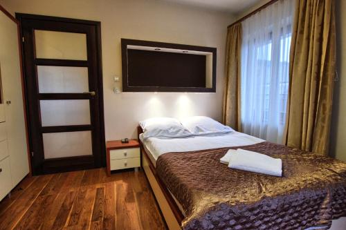 ザコパネにあるザコツェントゥルムのベッドとテレビが備わるホテルルームです。