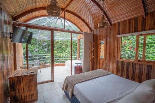 a bedroom with a bed and a tv in it at Mindo GlamBird Glamping & Lodge in Mindo