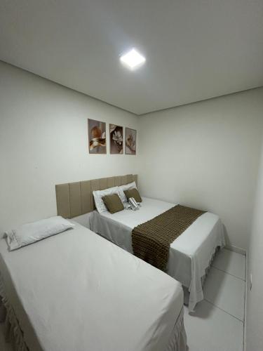two beds in a room with white walls at Casa siles in Mucugê