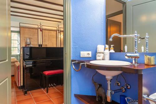 a bathroom with a sink in a blue wall at Centro Palafrugell: Casa con Piscina y Solárium in Palafrugell