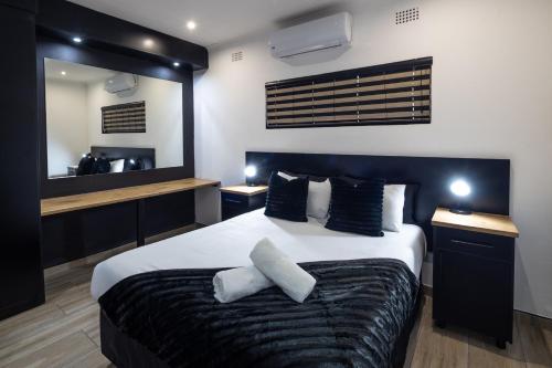 a bedroom with a large bed with two pillows at Fox Inn Guesthouse Lephalale in Lephalale