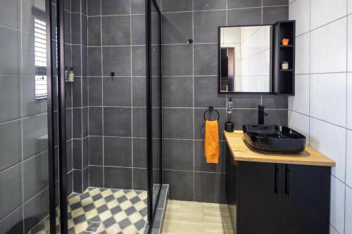 a bathroom with a black sink and a shower at Fox Inn Guesthouse Lephalale in Lephalale