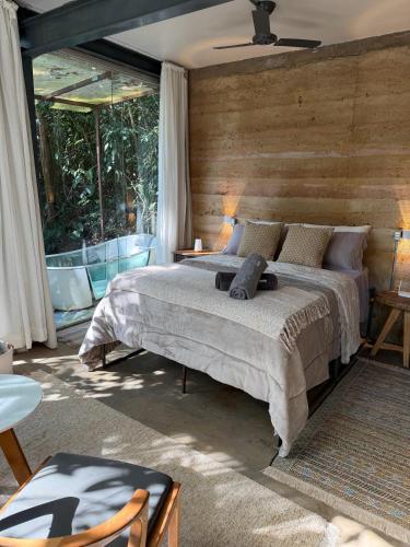a bedroom with a bed and a large window at Casa Aquário in Petrópolis