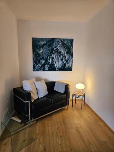 a living room with a black couch and a painting at Apartment 416 mit Pool in Lahnstein