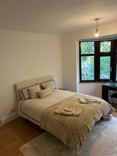 a bedroom with a large bed and a window at Newly Refurbished House in Norwood