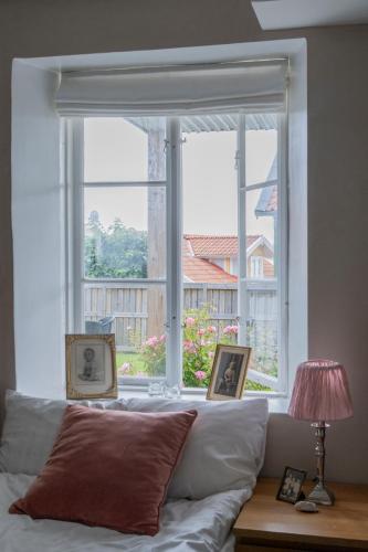 ein Fenster mit zwei Bildern, davor ein Sofa in der Unterkunft Villa Evalotta in Fjällbacka