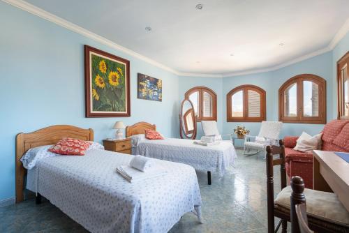 two beds in a room with blue walls and windows at Your Island Villa Son Serra in Son Serra de Marina