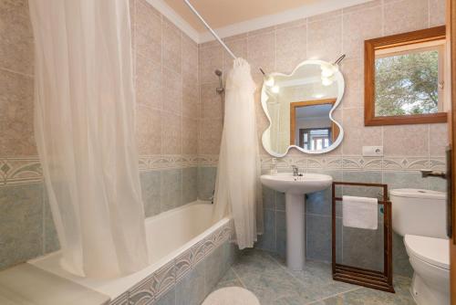 a bathroom with a tub and a sink and a mirror at Your Island Villa Son Serra in Son Serra de Marina