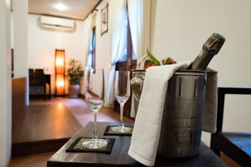 a bottle of wine sitting on a table with two glasses at Sanctuary Hotel Luang Prabang in Luang Prabang