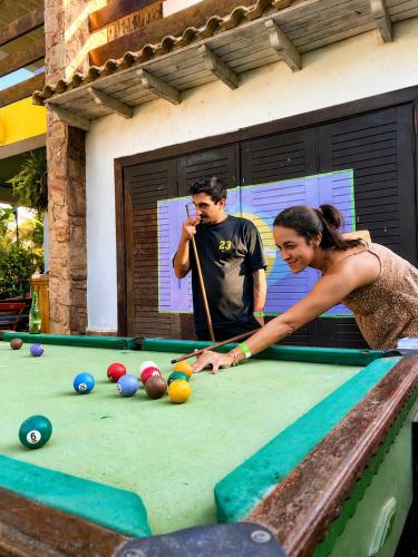 a man and a woman playing pool on a pool table at Hostel Mawe in Paraty