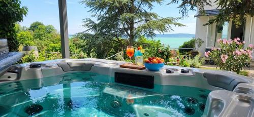 a hot tub in a backyard with a view of the ocean at Mirador Balaton Panorama Villa & Jacuzzi in Balatonakarattya
