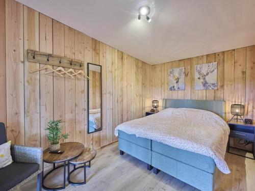 ein Schlafzimmer mit einem blauen Bett und Holzwänden in der Unterkunft Veldzicht in Bocholt