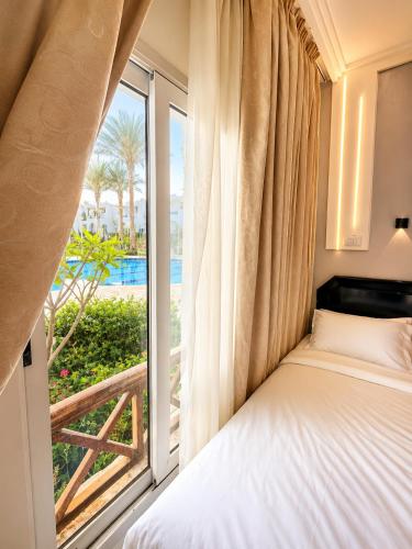 a bedroom with a bed and a large window at Private Luxury Villas at Sharm Dreams Vacation Club in Sharm El Sheikh