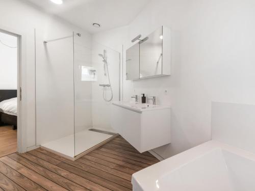 a white bathroom with a sink and a shower at t Loftje in Veurne