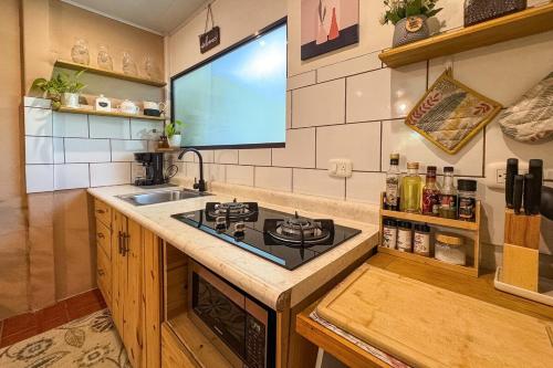 a kitchen with a sink and a stove top oven at Home Chic in Quepos