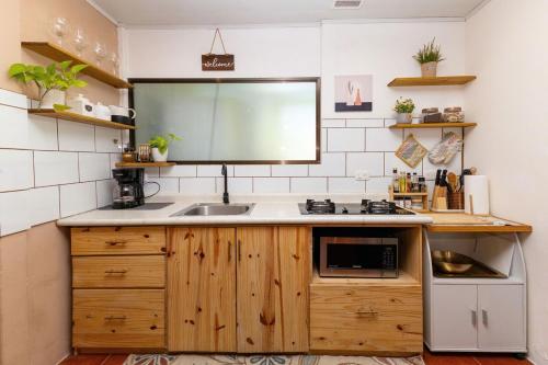 a kitchen with a sink and a microwave at Home Chic in Quepos