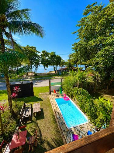 a swimming pool in a yard next to a beach at Hostel Mawe in Paraty