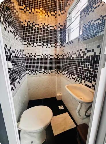 a bathroom with a toilet and a sink at Pousada N'ativaMar in Guaratuba