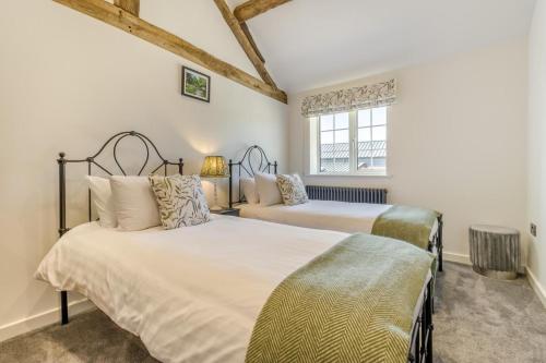 two beds in a room with white walls and a window at 7 Bed in Welshpool oc-96412 in Berriew