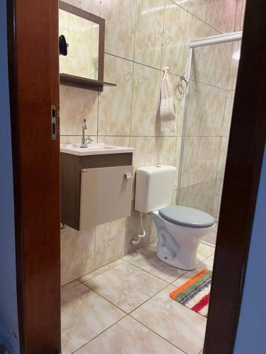 a bathroom with a toilet and a sink and a mirror at Recanto agape chalés e cabana in Rosas