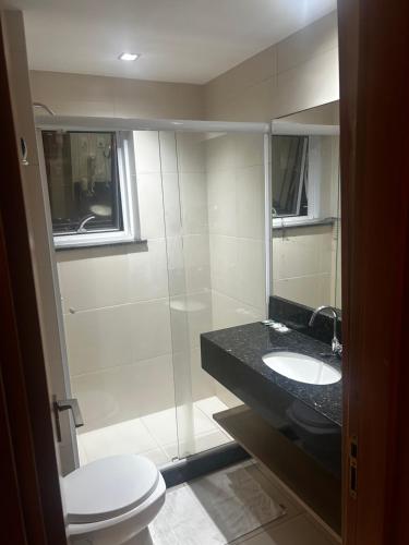a bathroom with a toilet and a sink and a shower at Diamond Flat Aparthotel REDE Mont Blanc in Nova Iguaçu
