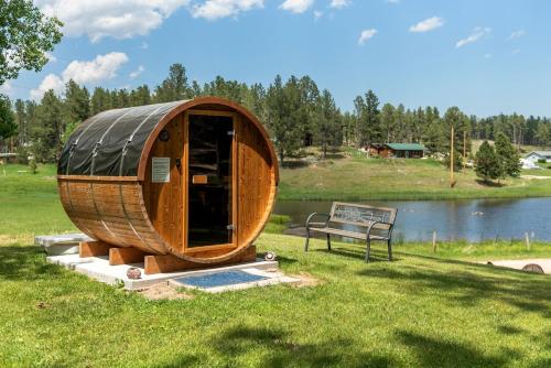 a wooden boat sitting next to a bench next to a lake at Rustic Sanctuary BHBungalows #7 in Custer