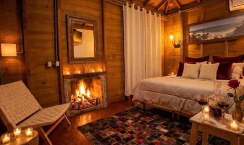 ein Schlafzimmer mit einem Bett, einem Kamin und einem Spiegel in der Unterkunft Pousada Ananda in Osório