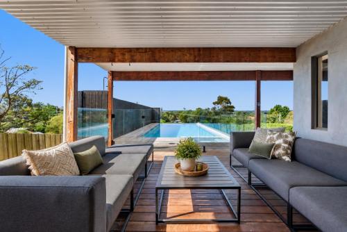 a patio with couches and a table and a pool at Nautilus by Ready Set Stay in Rye