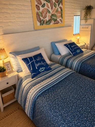 a bedroom with two beds with blue and white sheets at Apart Los Cerrillos in Balcarce