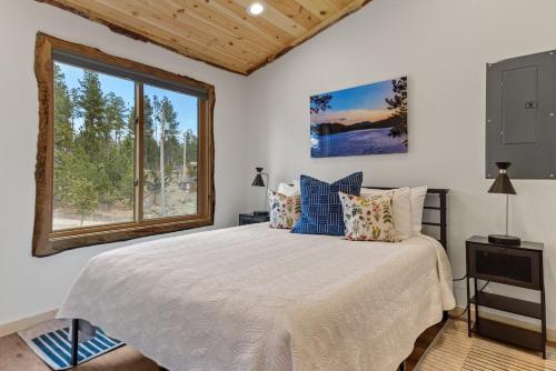 a bedroom with a large bed and a window at Hottub Haven BHBungalows #9 in Custer