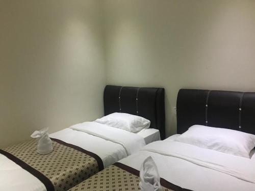 two beds sitting next to each other in a room at Qu Lin Resident in Sibu