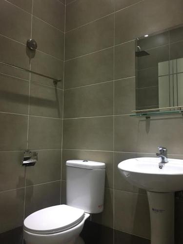 a bathroom with a toilet and a sink at Qu Lin Resident in Sibu