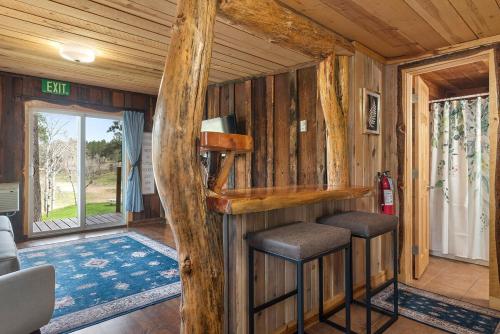 a room in a log cabin with two stools at Little Joy BHBungalows #4 in Custer
