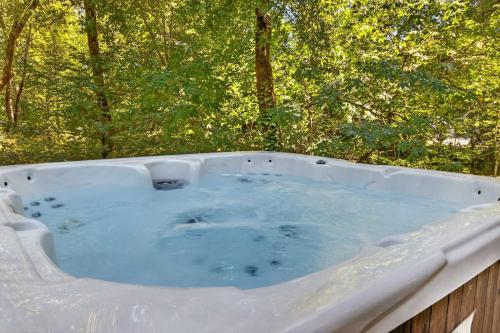 a hot tub in a garden with trees in the background at The Enso Sonoma in Glen Ellen