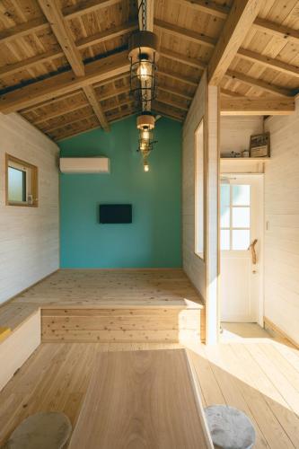 an empty room with a green wall and wooden ceilings at ヌックベル in Kumamoto