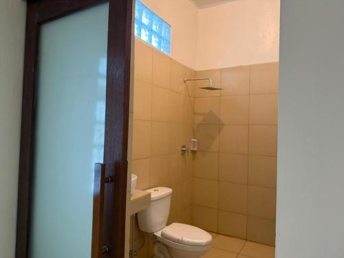 a bathroom with a toilet and a window at Hotel Orangutan in Bukit Lawang