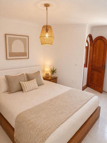 a bedroom with a large bed and a chandelier at Excelente villa With pool ibiza in Santa Gertrudis de Fruitera