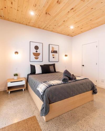 a bedroom with a bed and a wooden ceiling at Chalet OSLO in Saint Come