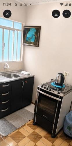 a kitchen with a stove and a sink at Casa Hospedagem 01 in Foz do Iguaçu