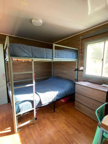 a bedroom with two bunk beds and a window at Cielo Tiny House in San Pedro de Atacama