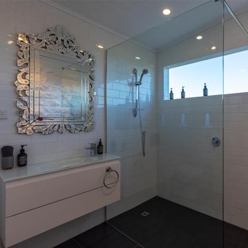 a bathroom with a shower and a sink and a mirror at Cape Nelson Lighthouse in Portland