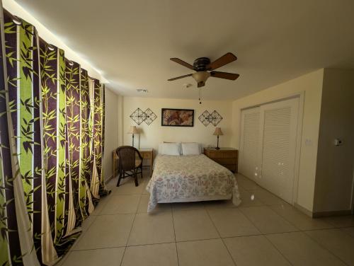 a bedroom with a bed and a ceiling fan at The Crown House Hotel in Philipsburg