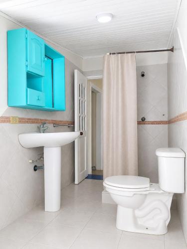 a bathroom with a toilet and a sink and a blue cabinet at Casa Hotel Terraza del Cabrero in Cartagena de Indias