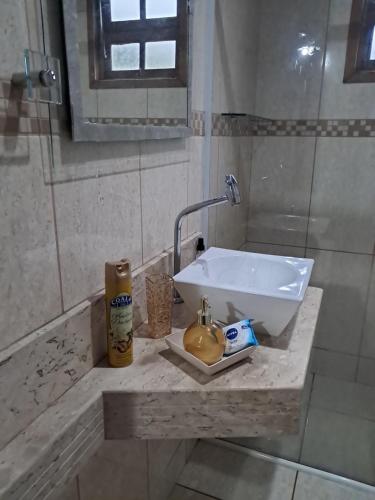 a bathroom counter with a sink and a mirror at Flat luxo e tranquilidade in Volta Redonda
