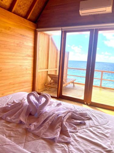 a bed in a room with a view of the ocean at Aresona Cliff House in Bira
