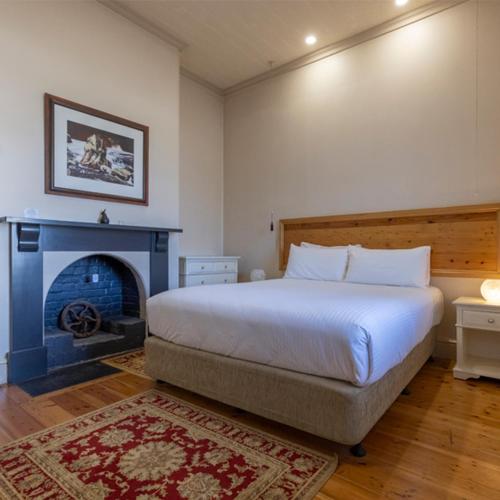 a bedroom with a large bed and a fireplace at Cape Nelson Lighthouse in Portland